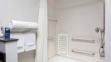 Une salle de bain équipée d’une baignoire, d’une douche, d’un porte-serviettes et d’une barre d’appui.