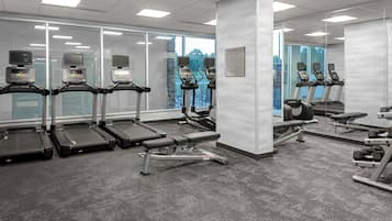 A gym with treadmills, a bench, and weight machines.