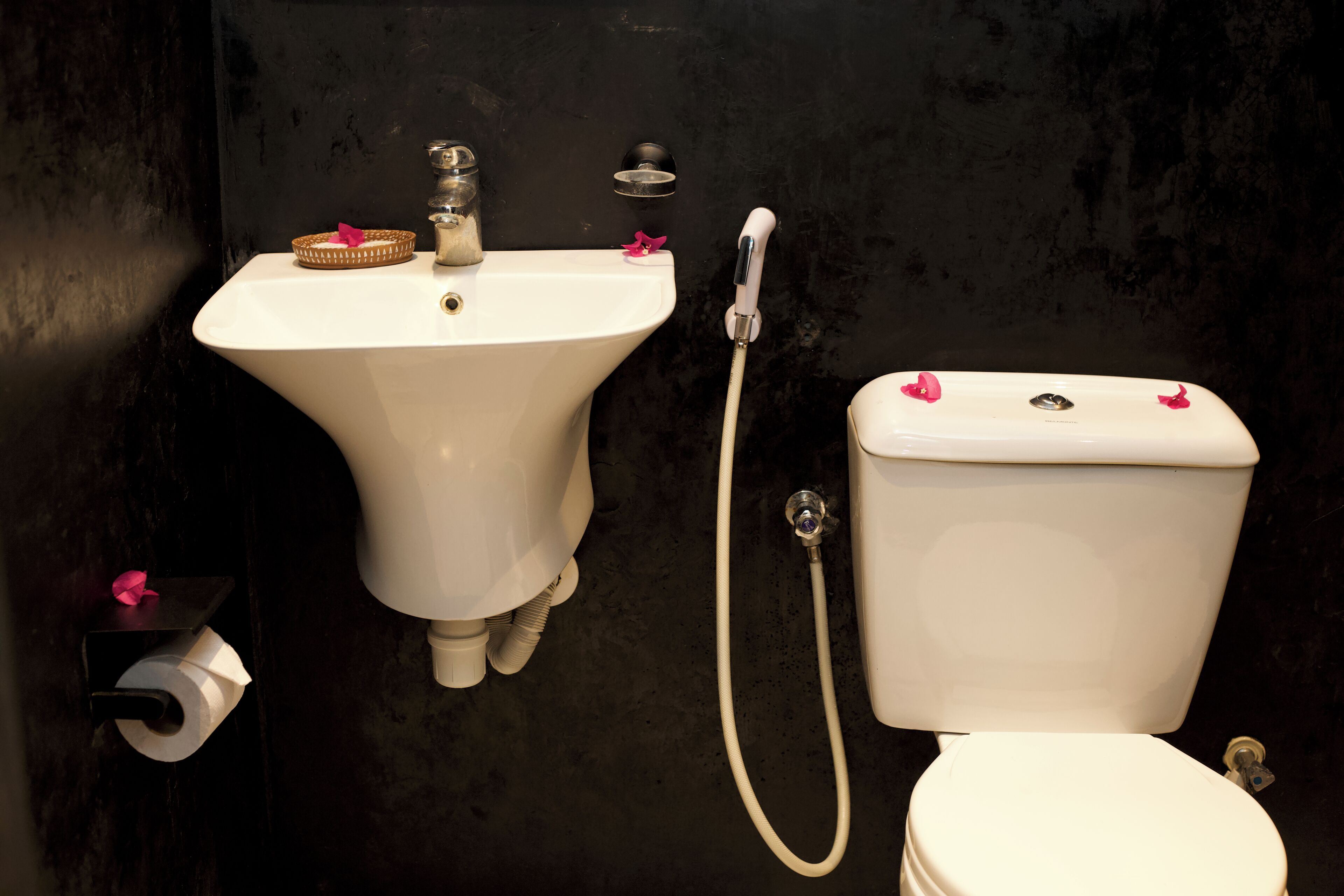 Un baño con lavamanos, inodoro y ducha blancos.