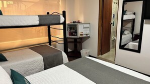 A dormitory room with bunk beds, a small kitchenette, a mirror, and a window with a view of a building. - Tita´s House Bogotá (Bogotá)