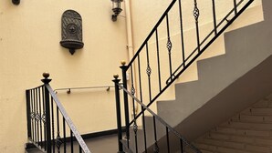 A staircase with black metal railings and a beige wall. - Tita´s House Bogotá (Bogotá)