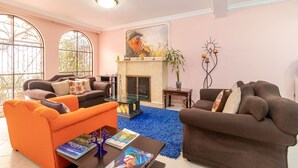 A living room with two sofas, a coffee table, a fireplace, and large windows. - Tita´s House Bogotá (Bogotá)