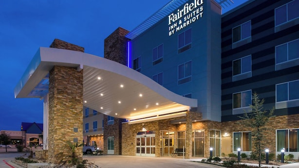 Un hotel Marriott Fairfield Inn & Suites con fachada de piedra, entrada amplia y un área exterior cubierta.