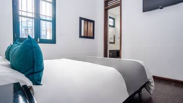 Ein Hotelzimmer mit Bett, Fenster, Spiegel und Fernseher.