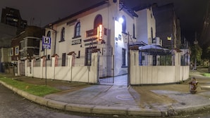 A white building with a sign indicating a hotel and a hospital. - Ayenda La Tua Casa (Bogotá)