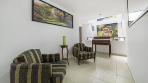 A living room with patterned sofas, a wooden side table, and a painting on the wall.