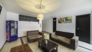 A modern living room with two sofas, a coffee table, and a decorative vase. - Hotel Elegant Suite (Bogotá)