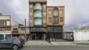 A hotel with a modern facade, large windows, and a gated entrance. - Hotel Elegant Suite (Bogotá)