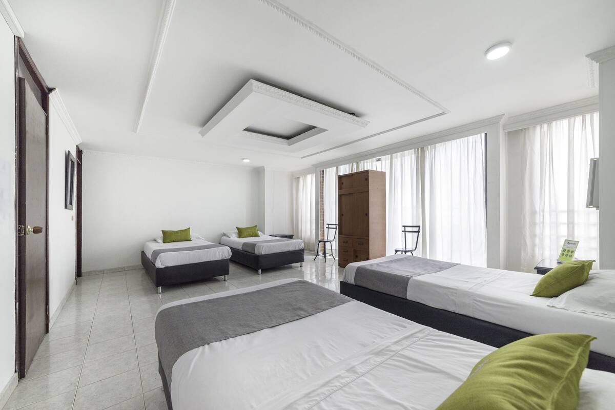 A hotel room with two beds, a desk, and a chair.