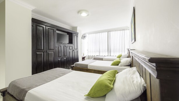 A hotel room with two beds, a wardrobe, a television, and a window with curtains. - Ayenda 1120 Comercial (Pereira)