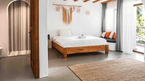 A bedroom with a wooden bed, a wall-mounted macrame piece, and a view of the outdoors. - Kassandra Ölüdeniz  (Fethiye)