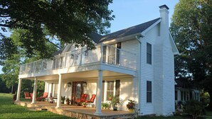 A two-story house with a covered porch, multiple windows, and a chimney. - Villa Cathedral (Alton)