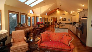 A spacious living room with a high ceiling, a dining area, and a kitchen. - Villa Cathedral (Alton)