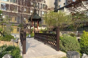 A gated entrance with a traditional pavilion, surrounded by greenery and a stone pathway. - Ziyun Hotel (Mianyang)