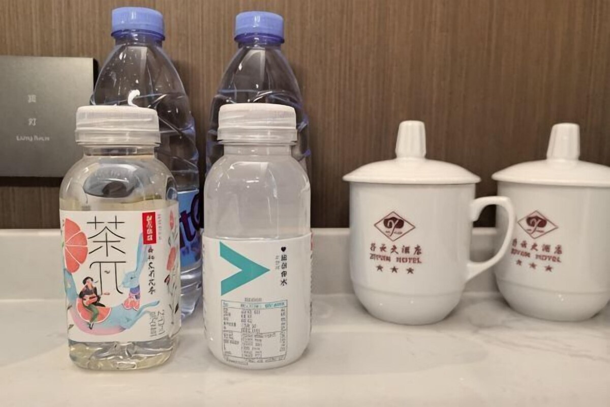 Eine Hotelminibar mit abgefüllten Getränken und einem Tee-Set.
