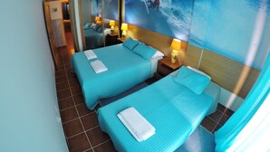 Habitación de hotel con dos camas, un espejo grande y un mural de un surfista sobre una ola.