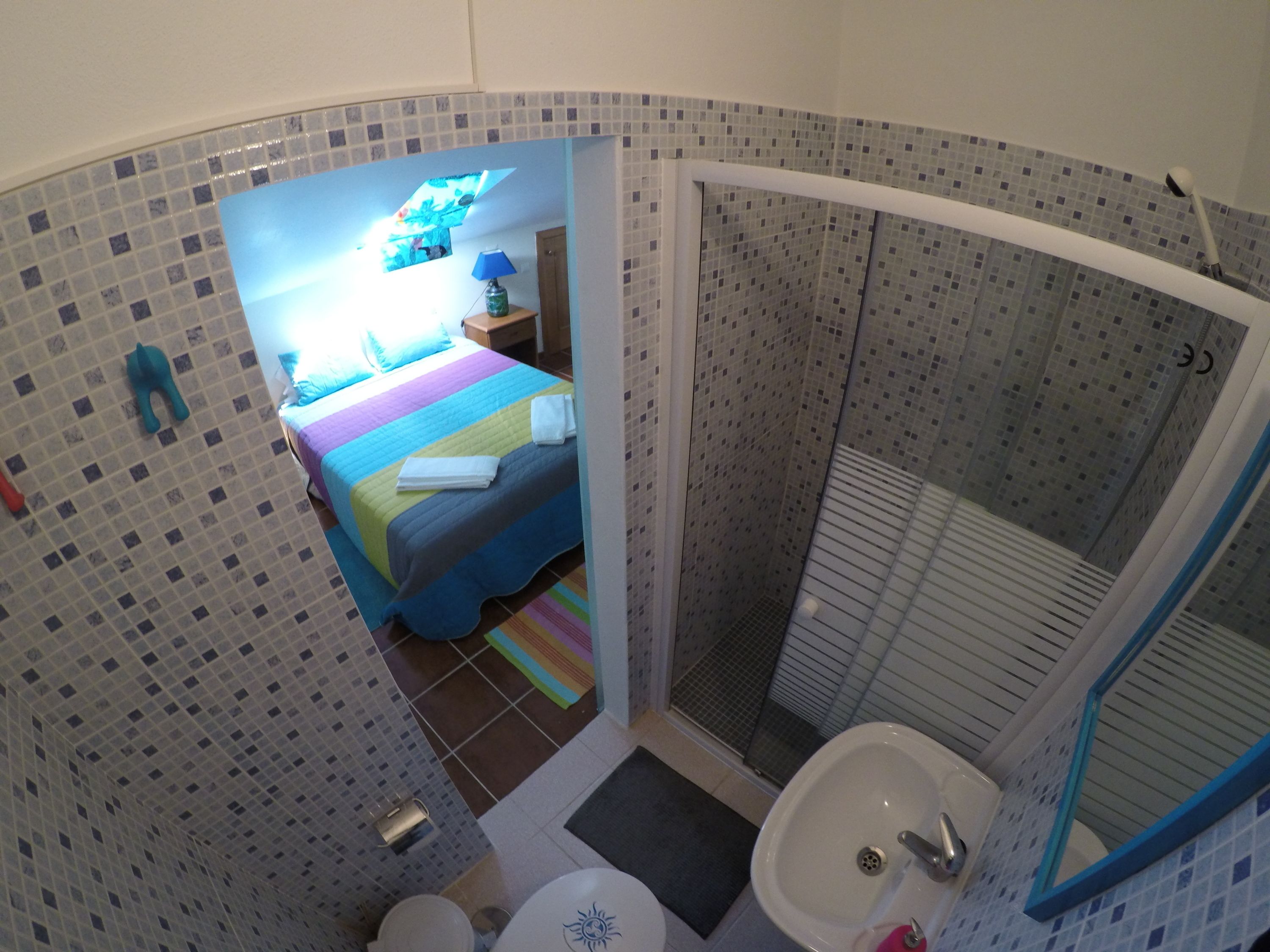 Een badkamer met een douche, wastafel en toilet.