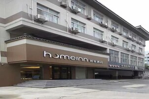 Un hotel con fachada moderna, una entrada destacada y una escalera visible que conduce a la entrada.