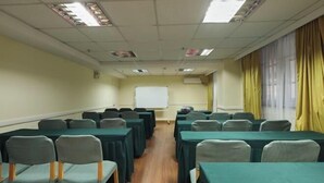 A conference room with rows of tables and chairs, a whiteboard, and a window with curtains. - Homeinn Hotel (Yangzhou Shouxihu Wenchang Pavilion) (Yangzhou)