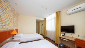 A hotel room with two beds, a TV, a desk, and an air conditioning unit. - Homeinn Hotel (Yangzhou Shouxihu Wenchang Pavilion) (Yangzhou)