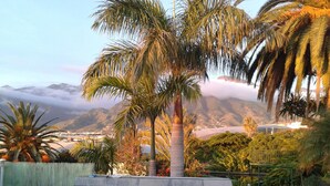 Une piscine offrant une vue sur les montagnes et un plan d’eau en arrière-plan.