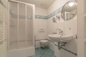 Ein Badezimmer mit Dusche, Toilette und Waschbecken.