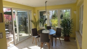 A dining area with a round table, four chairs, and a potted plant. - Bright vacation apartment with 68sqm and south-facing terrace for max. 4 people (Lindau (Bodensee))