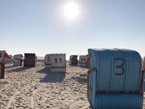 A beach with numbered beach chairs and umbrellas, indicating a rental area. - Four star accommodation in Friesenhörn, quiet south facing, right on the dike (Horumersiel)