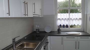 Een koelkast, een oven, een kookplaat, een vaatwasser