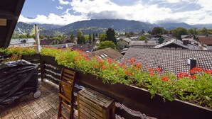 Un balcon avec vue sur un village et des montagnes.