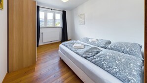 Une chambre à coucher avec un lit, une fenêtre, un radiateur et un luminaire au plafond.