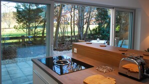 A modern kitchen with a large window, a built-in stove, and a toaster. - Tegernsee Chalet vacation homeexceptional (Gmund am Tegernsee)