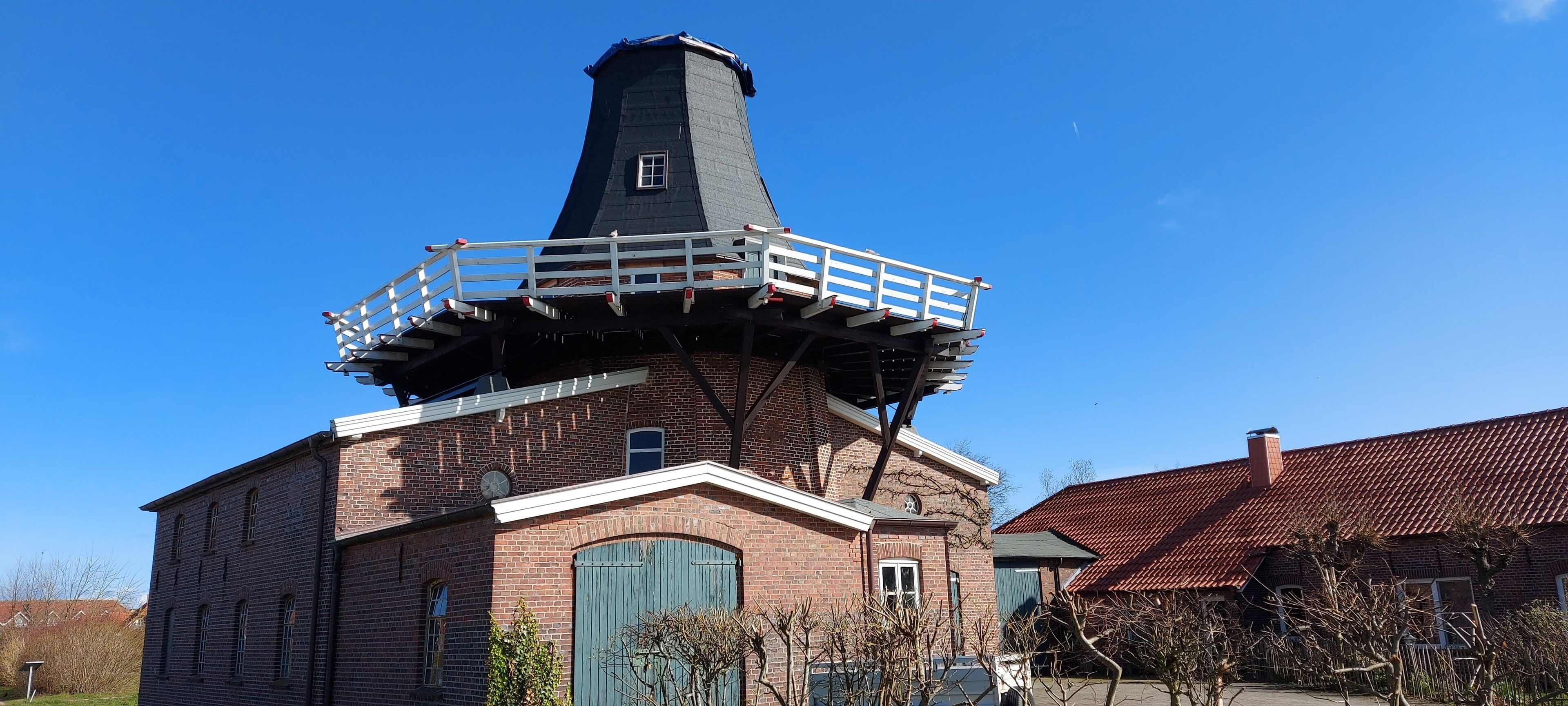 Un edificio de ladrillo con una torre destacada y un balcón.