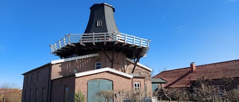 Un bâtiment en briques doté d’une tour imposante et d’un balcon.