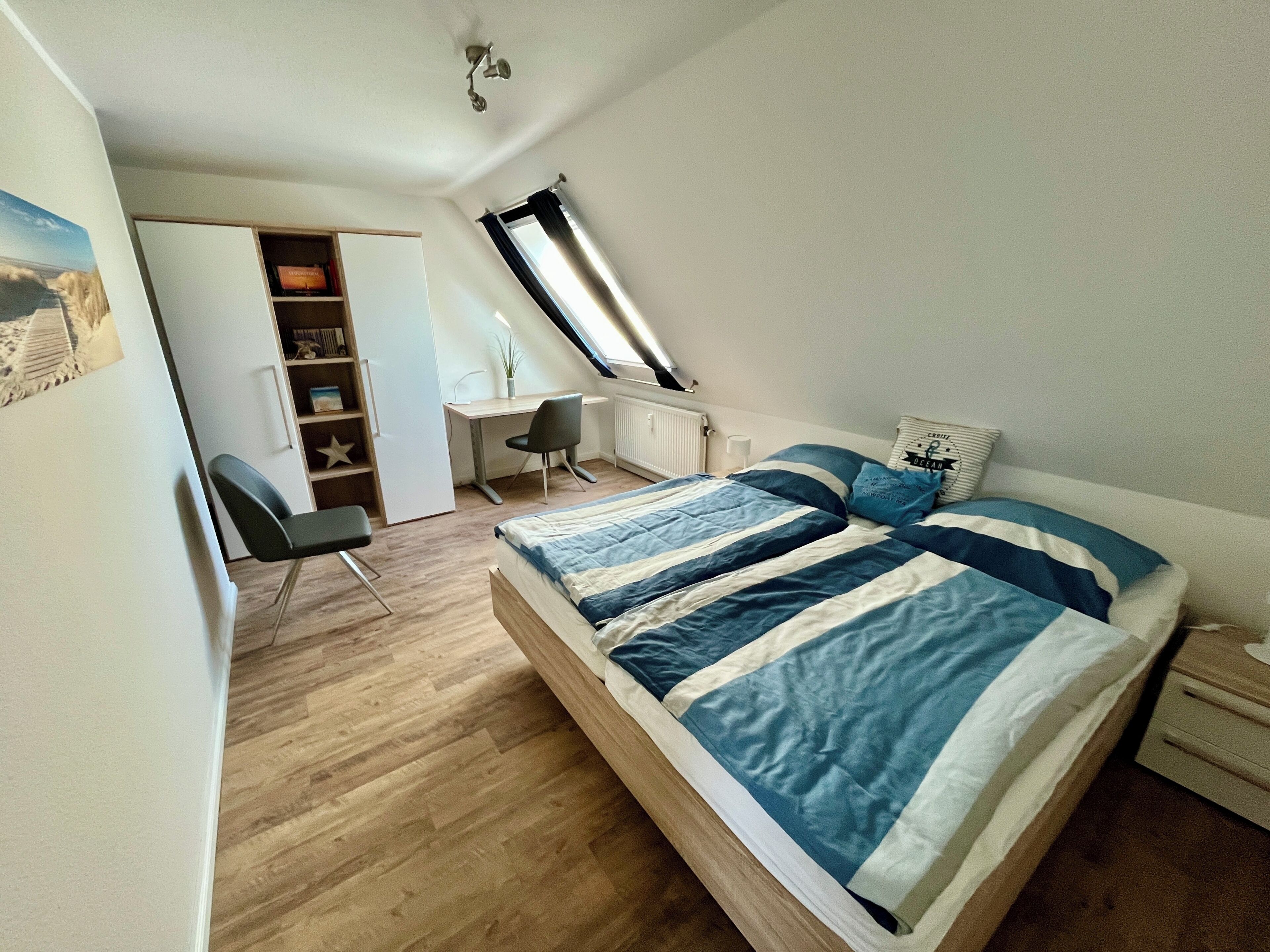 Ein Schlafzimmer mit einem Bett, einem Schreibtisch und einem Stuhl.