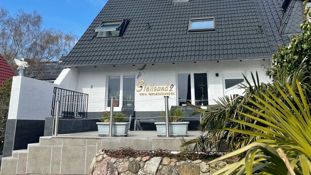 Un edificio con un letrero que dice "Steilsand2" y una dirección web.