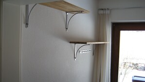 Una habitación con un estante de madera en la pared y un estante metálico debajo.