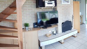 A living room with a TV, speakers, and a fireplace. - A beautiful house with incredible views on a corner lot (Sint Maarten)