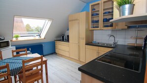 Une cuisine moderne avec des meubles en bois, un plan de travail noir et une fenêtre offrant une belle vue.