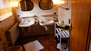 Un baño pequeño con dos lavamanos, un inodoro y una ducha.