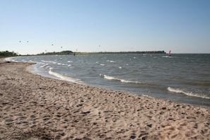 A sandy beach with gentle waves and a clear sky.