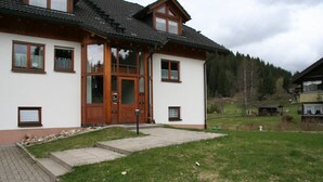 A two-story house with a wooden facade, a tiled roof, and a front porch. - In the southern Black Forest. Pure nature, close to the lake, family-friendly (Baden-Württemberg)