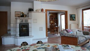 A cozy living room with a fireplace, a sofa, a dining table, and a bookshelf. - In the southern Black Forest. Pure nature, close to the lake, family-friendly (Baden-Württemberg)