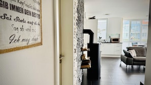 Een modern interieur met een keukenhoek, een bank en een open haard.