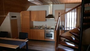 Una cocina con armarios de madera, estufa y lavaplatos.