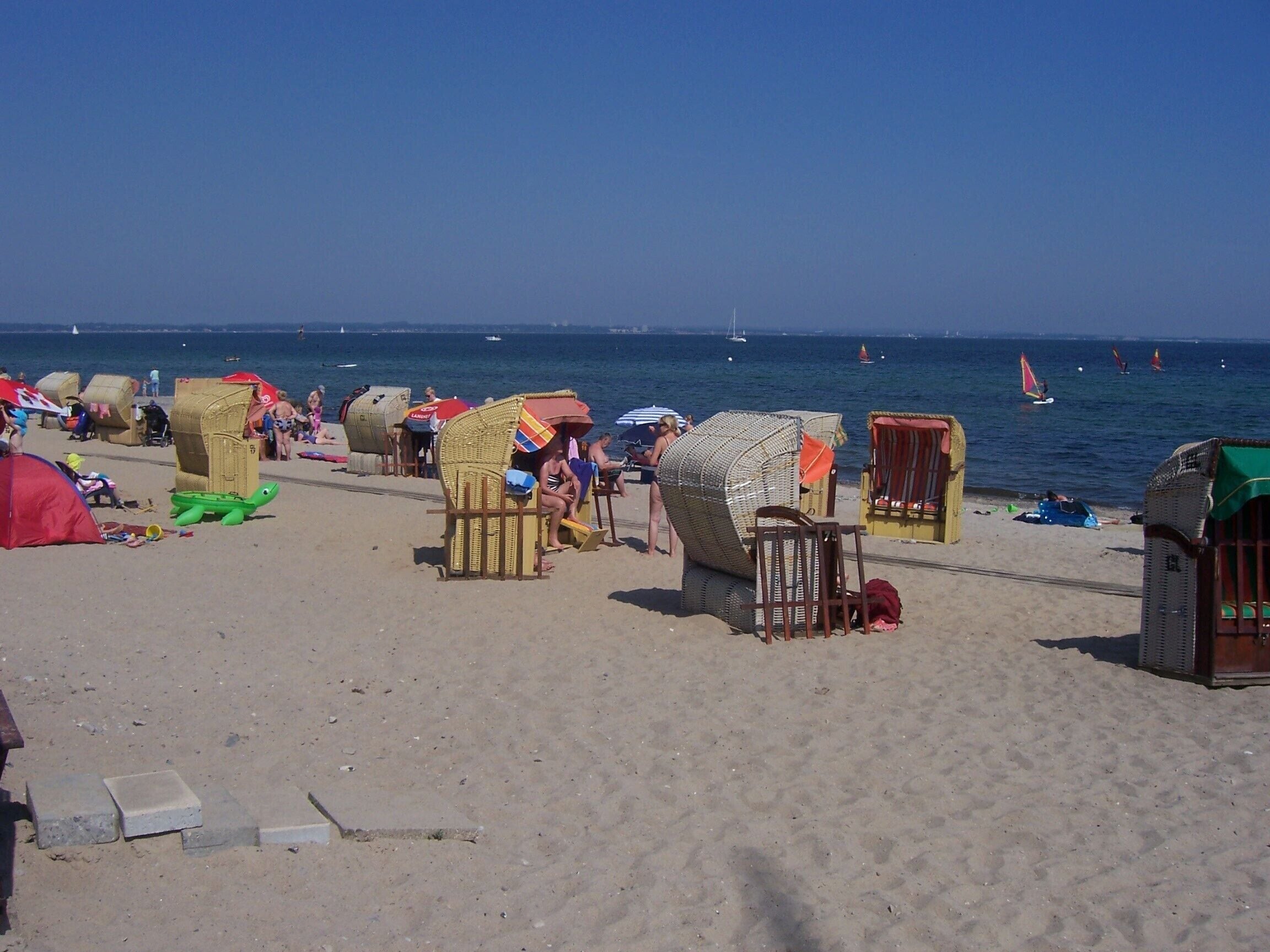 Een strand met verschillende strandhutten en een tent.