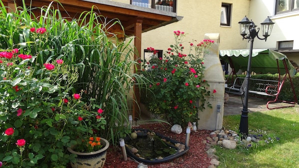 Un jardin agrémenté de plantes en pot et d’un petit étang.