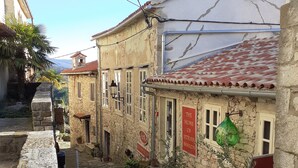 Una stretta strada acciottolata fiancheggiata da edifici in pietra, una bicicletta e vasi con piante.