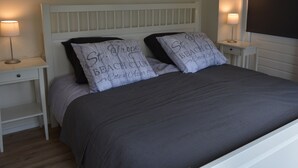 A neatly made bed with a white headboard and two bedside tables, each with a lamp.