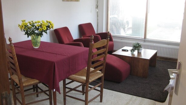 Comedor con una mesa dispuesta para cuatro personas, rodeado de sillas de madera.
